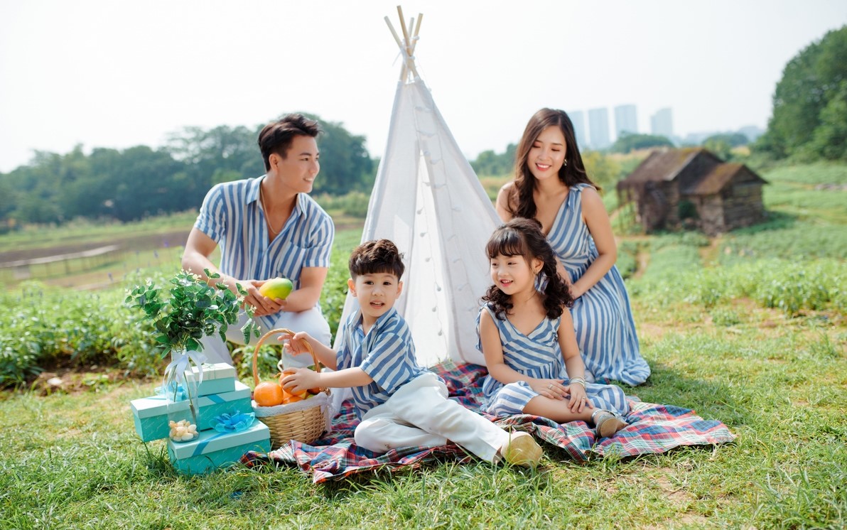 Chụp ảnh gia đình mùa hè với đồng cỏ và hoa rực rỡ
